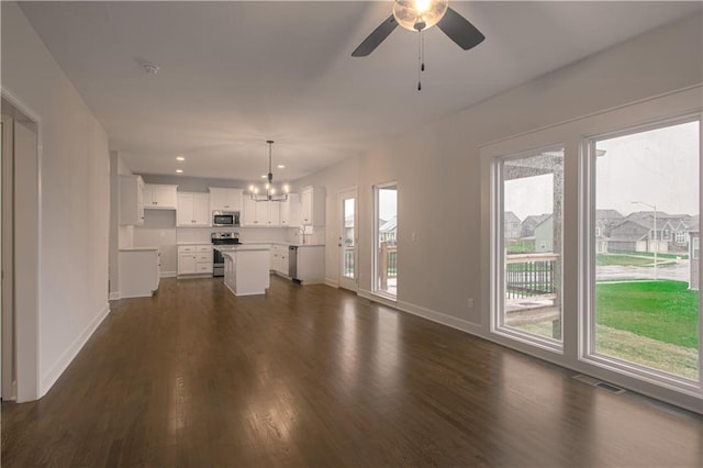 6106 NE 118th St, Kansas City, MO 64156 - unfurnished living room with a chandelier, baseboards, dark wood finished floors, ceiling fan, and recessed lighting