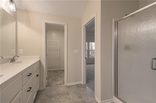 6106 NE 118th St, Kansas City, MO 64156 - bathroom featuring a shower stall, baseboards, double vanity, a walk in closet, and lofted ceiling