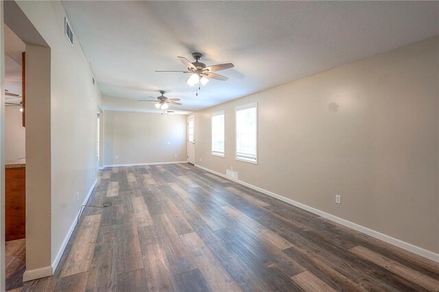 507 W 26th St, Higginsville, MO 64037 - empty room featuring a ceiling fan, dark wood-style floors, and baseboards