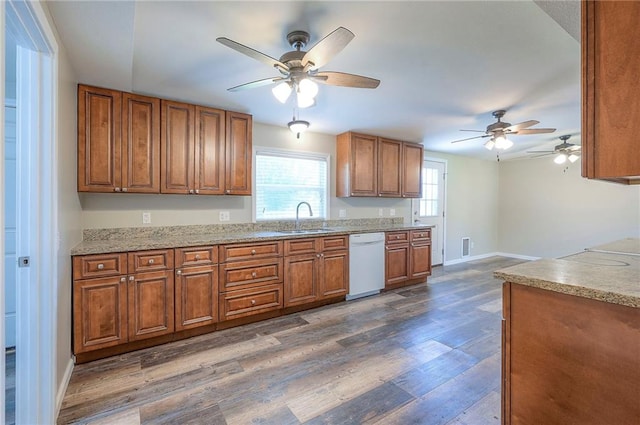 507 W 26th St, Higginsville, MO 64037 - kitchen with white dishwasher, a ceiling fan, brown cabinetry, and a sink