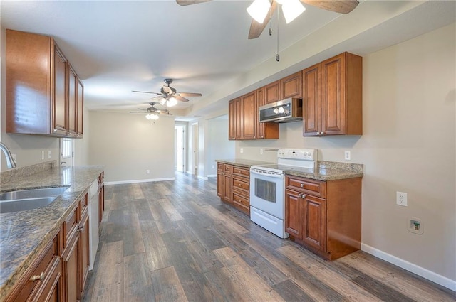 507 W 26th St, Higginsville, MO 64037 - kitchen with white appliances, a ceiling fan, a sink, brown cabinetry, and dark wood finished floors