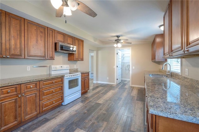 507 W 26th St, Higginsville, MO 64037 - kitchen with white range with electric stovetop, stainless steel microwave, a sink, and ceiling fan