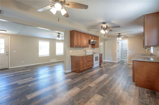 507 W 26th St, Higginsville, MO 64037 - kitchen featuring white range with electric cooktop, stainless steel microwave, brown cabinets, a ceiling fan, and baseboards