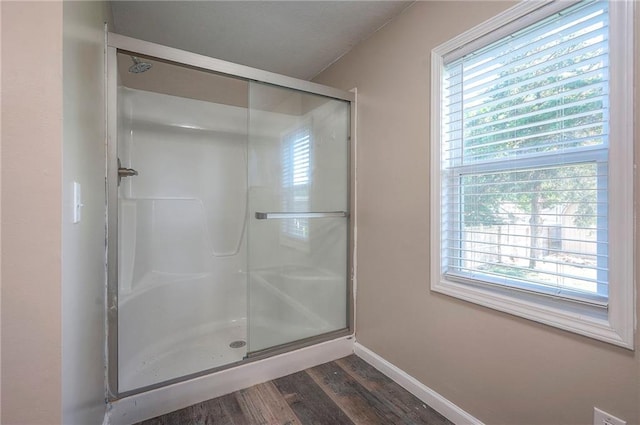 507 W 26th St, Higginsville, MO 64037 - bathroom featuring a stall shower, wood finished floors, healthy amount of natural light, and baseboards