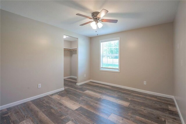 507 W 26th St, Higginsville, MO 64037 - unfurnished bedroom with dark wood-style flooring, baseboards, a closet, and a ceiling fan