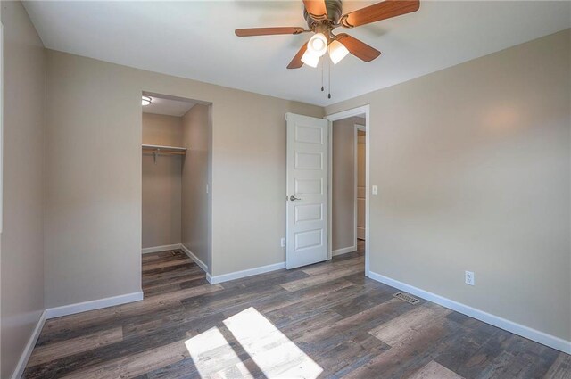507 W 26th St, Higginsville, MO 64037 - unfurnished bedroom with wood finished floors, baseboards, a closet, a ceiling fan, and a spacious closet