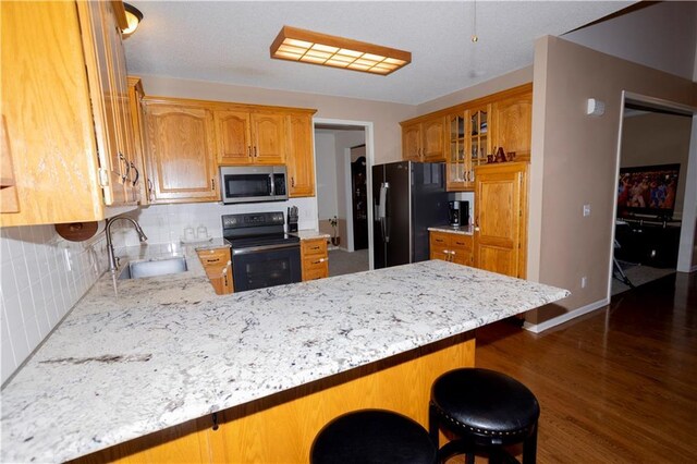 16366 S Hunter St, Olathe, KS 66062 - kitchen featuring black appliances, a sink, backsplash, a peninsula, and dark wood-style flooring
