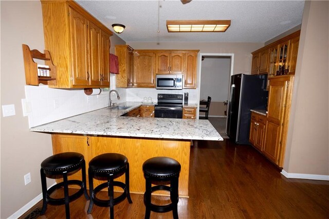 16366 S Hunter St, Olathe, KS 66062 - kitchen with black appliances, a sink, a peninsula, dark wood-style flooring, and baseboards