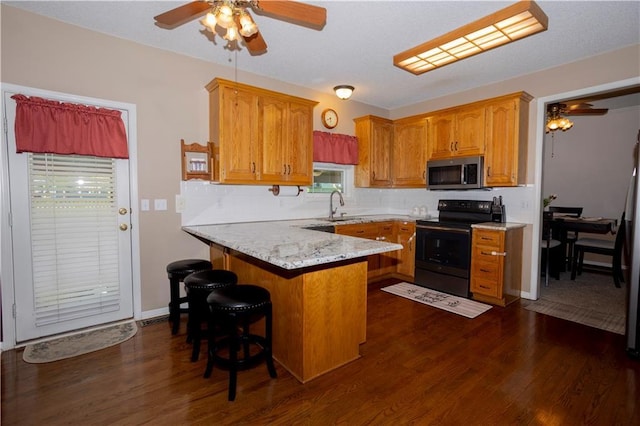 16366 S Hunter St, Olathe, KS 66062 - kitchen featuring black / electric stove, stainless steel microwave, ceiling fan, a peninsula, and dark wood-style flooring