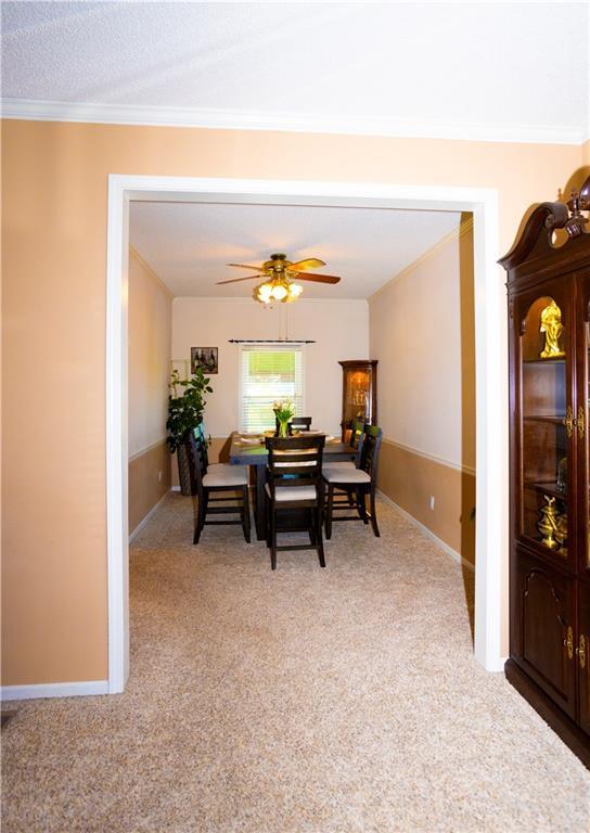 16366 S Hunter St, Olathe, KS 66062 - dining area with light carpet, ornamental molding, ceiling fan, and baseboards