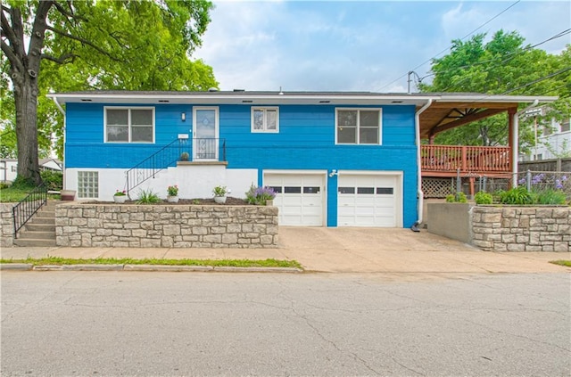 4547 Wyoming St, Kansas City, MO 64111 - view of front of house featuring stairway, a garage, and driveway