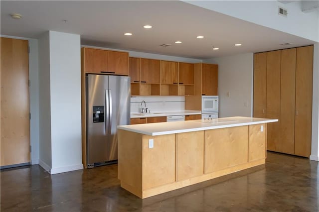 kitchen with white appliances, finished concrete floors, a sink, recessed lighting, and light countertops