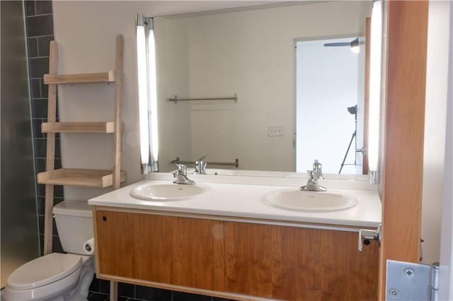 bathroom with toilet and double vanity