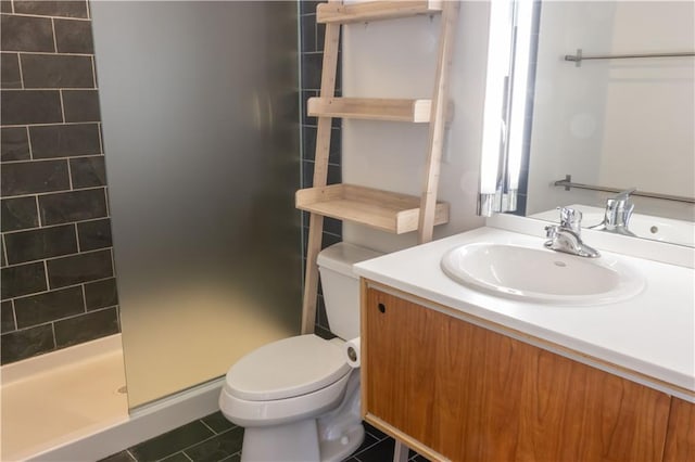 bathroom featuring toilet, a stall shower, tile patterned floors, and vanity