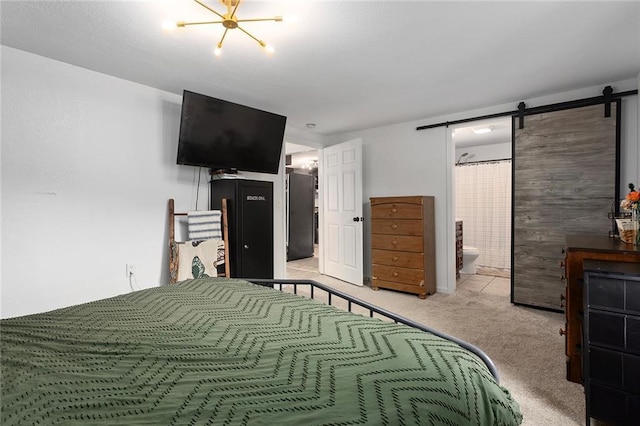 carpeted bedroom featuring a barn door and connected bathroom