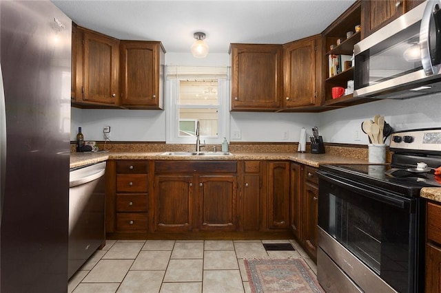 kitchen featuring stainless steel appliances, a sink, open shelves, and light tile patterned floors
