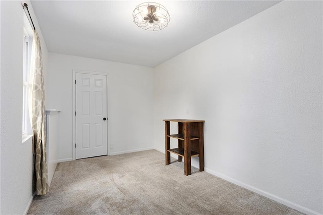 carpeted spare room featuring baseboards