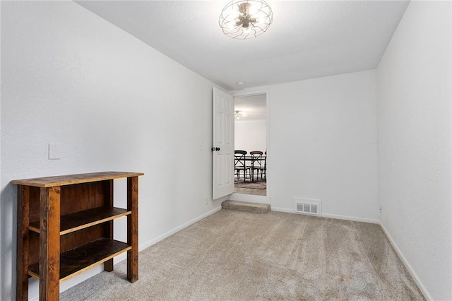 carpeted spare room featuring baseboards
