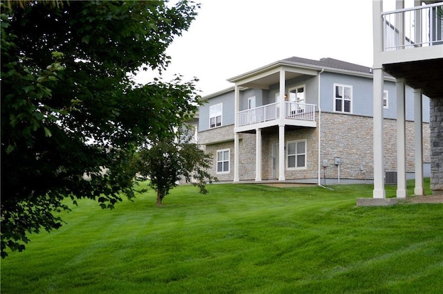 21962 W 116th Ter, Olathe, KS 66061 - rear view of property featuring a balcony, stone siding, a yard, and stucco siding