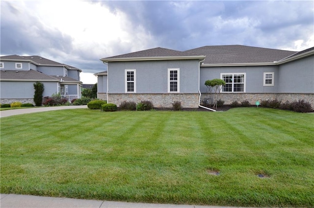21962 W 116th Ter, Olathe, KS 66061 - view of side of property featuring stone siding, a lawn, and stucco siding