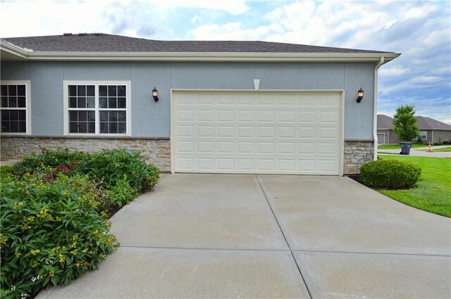 21962 W 116th Ter, Olathe, KS 66061 - view of property exterior with stone siding, driveway, an attached garage, and stucco siding