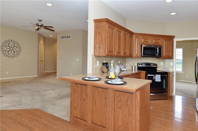 21962 W 116th Ter, Olathe, KS 66061 - kitchen with appliances with stainless steel finishes, a ceiling fan, brown cabinetry, recessed lighting, and backsplash