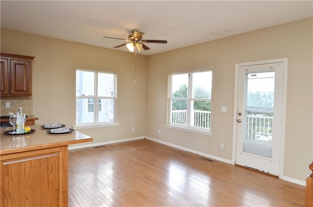 21962 W 116th Ter, Olathe, KS 66061 - kitchen with ceiling fan, light wood-style flooring, light countertops, tasteful backsplash, and brown cabinets