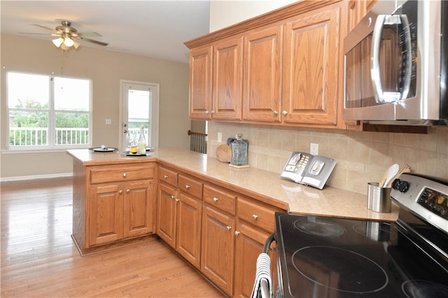 21962 W 116th Ter, Olathe, KS 66061 - kitchen featuring stainless steel appliances, a peninsula, light countertops, a ceiling fan, and light wood-type flooring