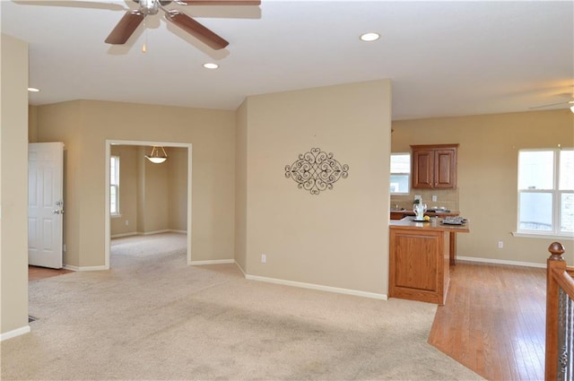 21962 W 116th Ter, Olathe, KS 66061 - unfurnished living room featuring a ceiling fan, plenty of natural light, recessed lighting, and light carpet