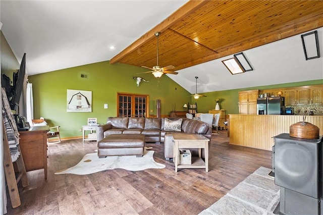 living room featuring a ceiling fan, wood finished floors, beamed ceiling, high vaulted ceiling, and baseboards