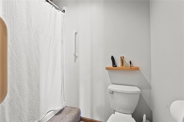 bathroom featuring toilet and a shower with shower curtain
