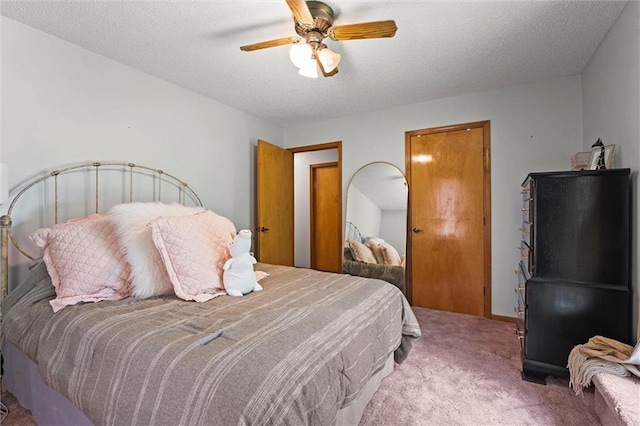 bedroom featuring carpet flooring, ceiling fan, and a textured ceiling