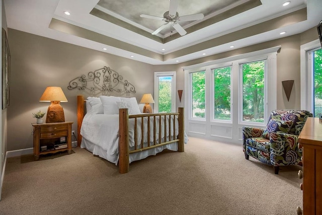 carpeted bedroom with ornamental molding, a raised ceiling, recessed lighting, and ceiling fan