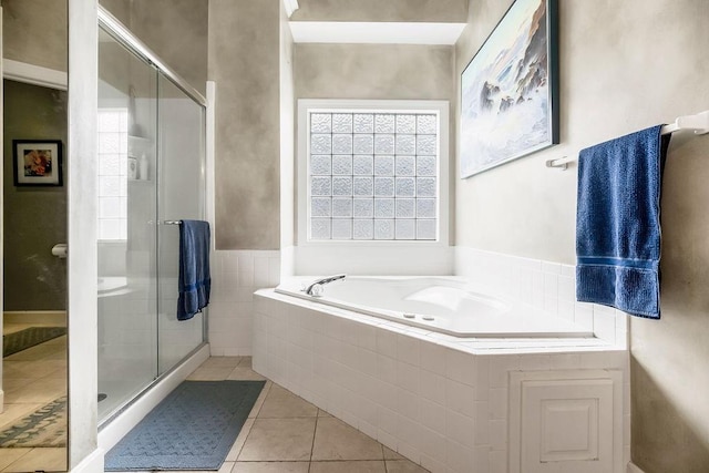bathroom with a stall shower, a bath, and tile patterned flooring