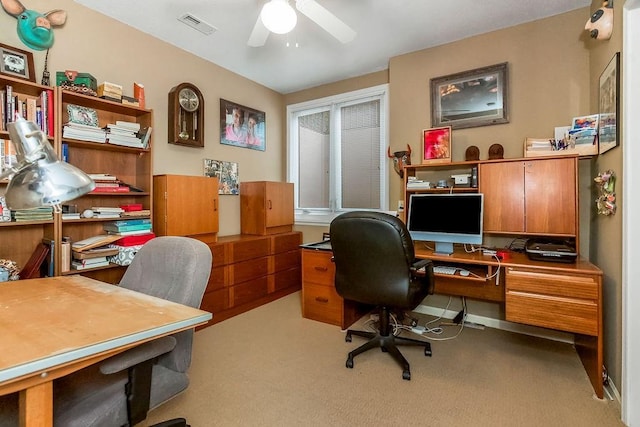 carpeted office space with a ceiling fan