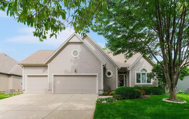 view of front of property featuring an attached garage, concrete driveway, a front yard, and stucco siding