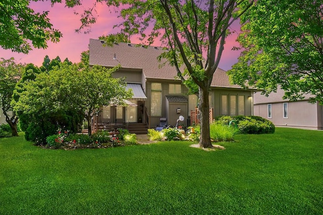 rear view of property featuring a yard
