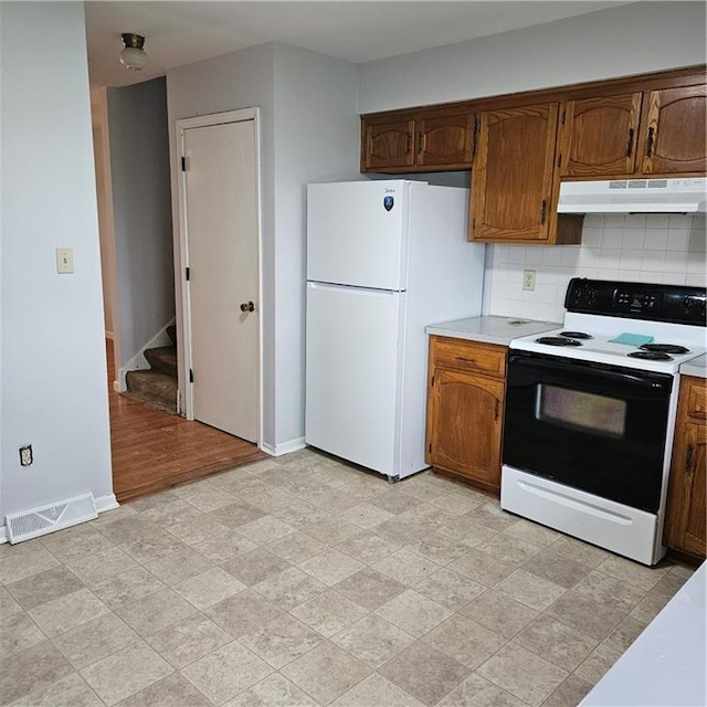 8413-8415 E 170th St, Belton, MO 64012 - kitchen with electric range, under cabinet range hood, freestanding refrigerator, tasteful backsplash, and light countertops