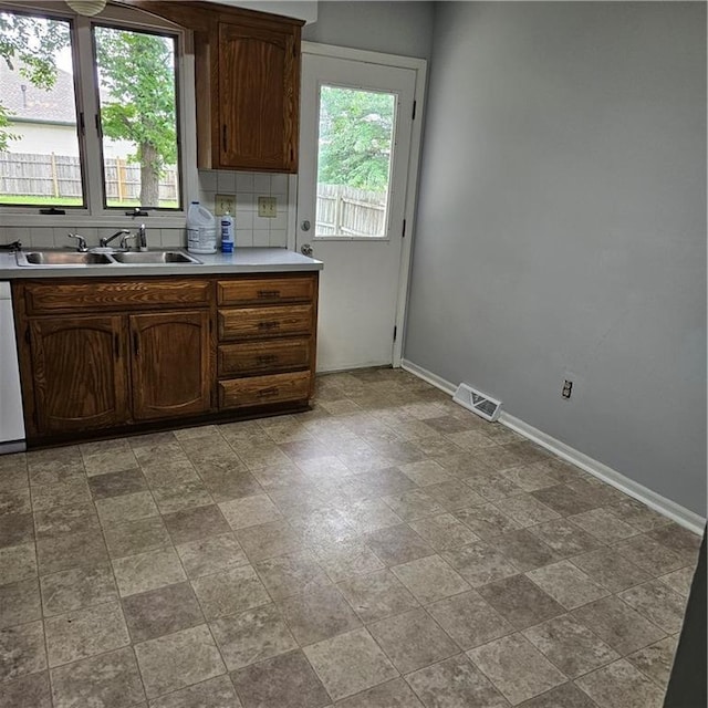 8413-8415 E 170th St, Belton, MO 64012 - kitchen with a sink, baseboards, light countertops, dishwasher, and decorative backsplash