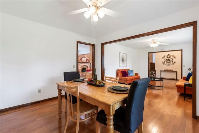 16280 Nall Ave, Stilwell, KS 66085 - dining space featuring a ceiling fan, light wood-style flooring, and a large fireplace