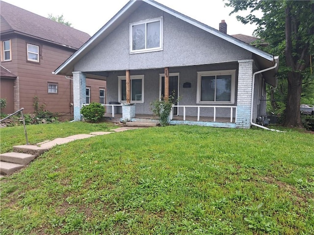 32 S Bethany Ave, Kansas City, KS 66102 - bungalow-style home featuring brick siding, a chimney, a front yard, stucco siding, and covered porch
