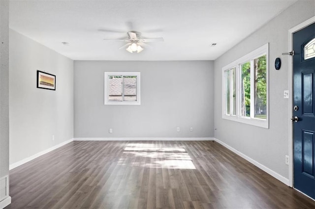 foyer with dark wood finished floors, a ceiling fan, and baseboards