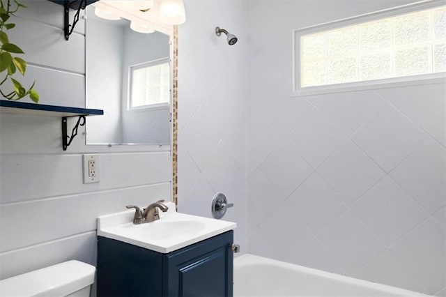 bathroom with toilet, vanity, and shower / bathtub combination