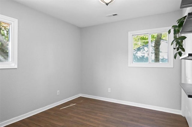 unfurnished room with dark wood-type flooring and baseboards