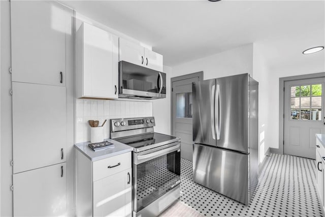 1508 SW Smith St, Blue Springs, MO 64015 - kitchen featuring stainless steel appliances, light countertops, white cabinetry, and backsplash