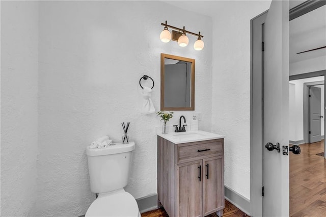 1508 SW Smith St, Blue Springs, MO 64015 - bathroom featuring a textured wall, wood finished floors, toilet, and vanity