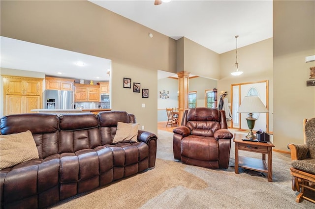 living area with decorative columns, light colored carpet, a high ceiling, and recessed lighting