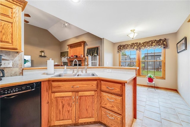 kitchen with black dishwasher, a sink, a peninsula, light countertops, and vaulted ceiling