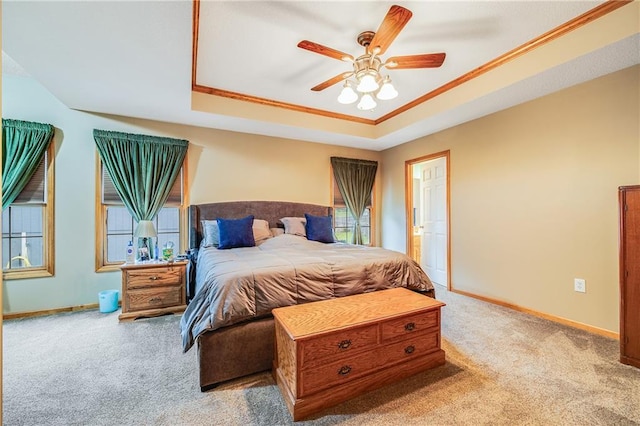 bedroom featuring carpet, a raised ceiling, baseboards, ornamental molding, and a ceiling fan