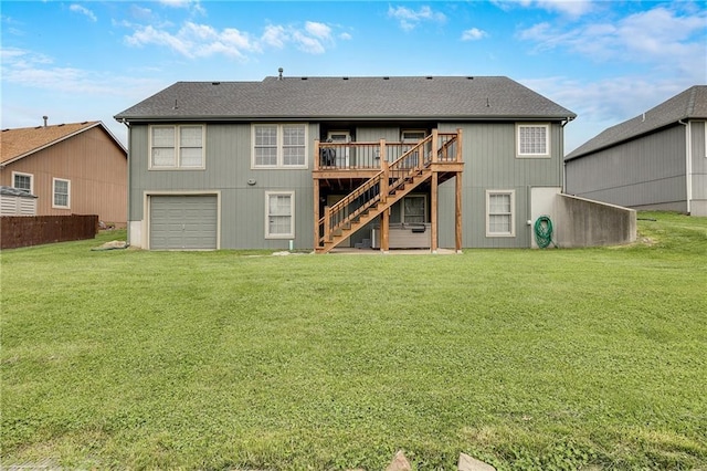 rear view of property featuring stairway, a wooden deck, a garage, and a yard